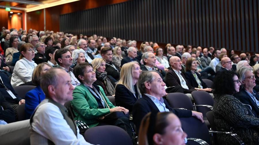 Ein voll besetzter Saal mit Menschen, die gespannt nach vorne blicken